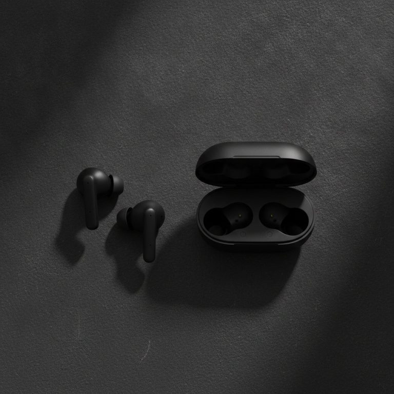 Ecouteurs intra-auriculaires noirs poses sur une surface sombre a cote de leur boitier ouvert